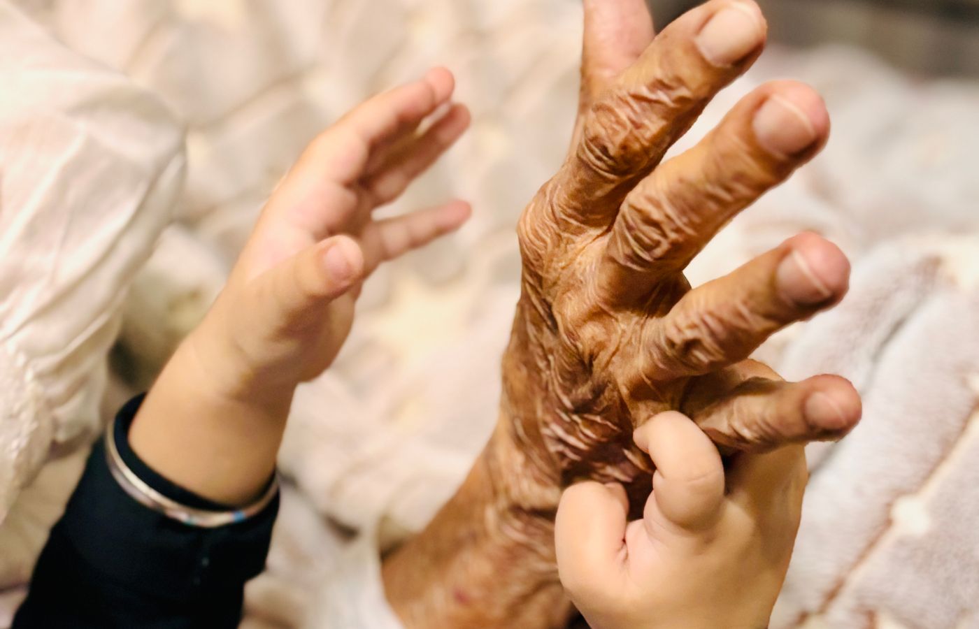A child's hand resting in the hand of an older relative