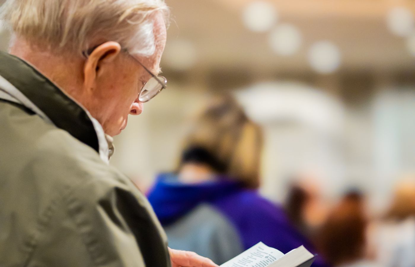 An older man reading quietly indoors