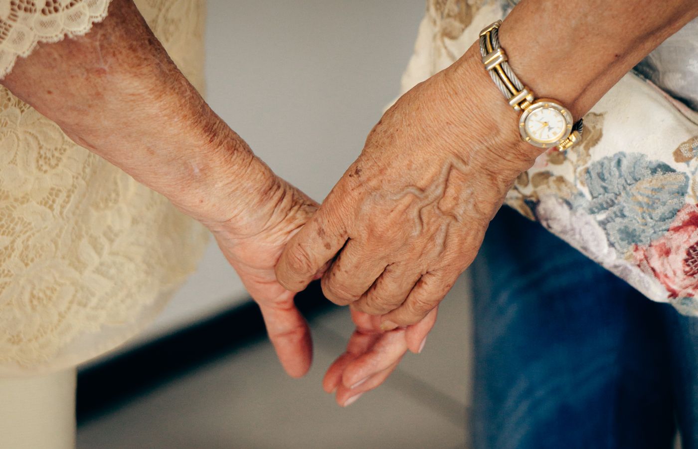 Two older hands clasped together in a tender moment