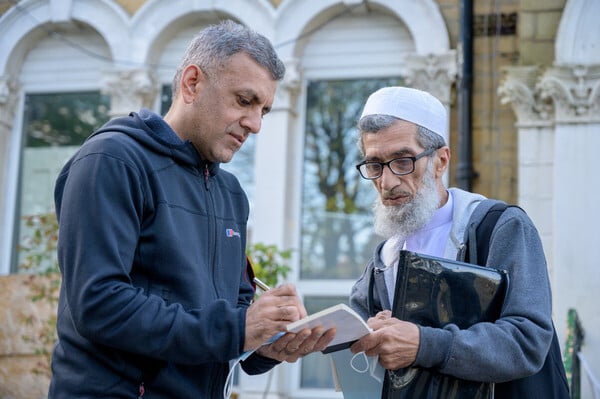 Two neighbours talking warmly on a doorstep