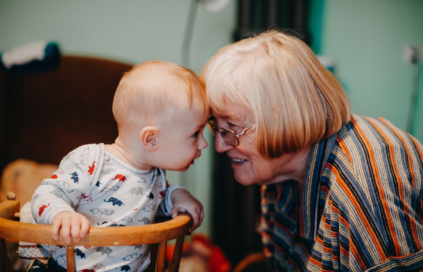 A grandmother touching foreheads with her baby grandchild