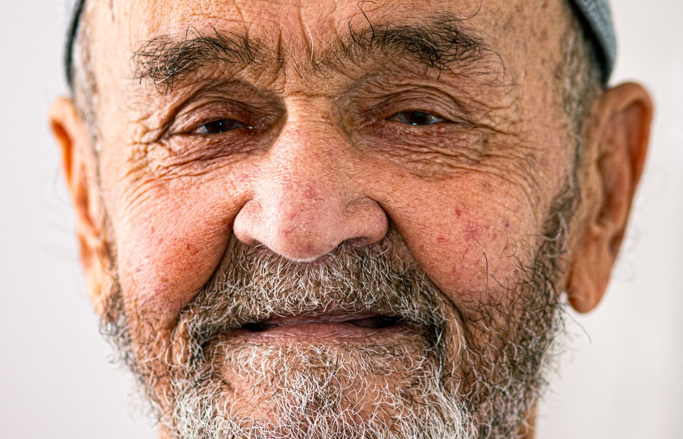 A warm portrait of an older man with a grey beard