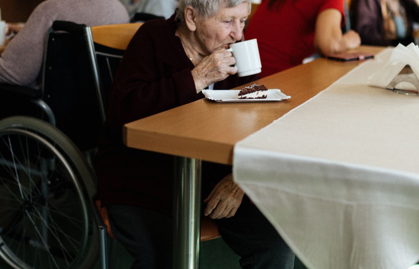 Older adults enjoying cake and coffee together at a table