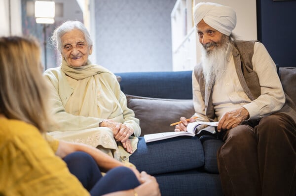 An older couple reading together on their sofa